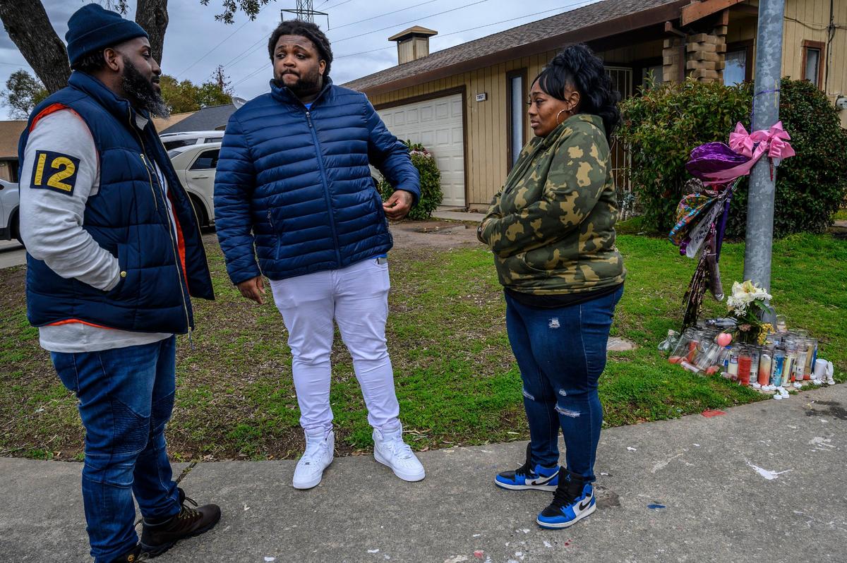 Berry Accius, left, Founder of She Could Be My Daughter, a support program for domestic violence victims, visits Dajha Richards’ mother Ebony Douglas, right, and step-father Andre Douglas, center, near a memorial for Dajha, who was shot and killed in their garage a month earlier on Monday, Feb. 4, 2019 in Sacramento.
