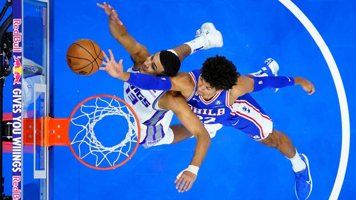 Philadelphia 76ers’ Matisse Thybulle, right, and Sacramento Kings’ Keegan Murray reach for a rebound during the first half of an NBA basketball game, Tuesday, Dec. 13, 2022, in Philadelphia. (AP Photo/Matt Slocum)