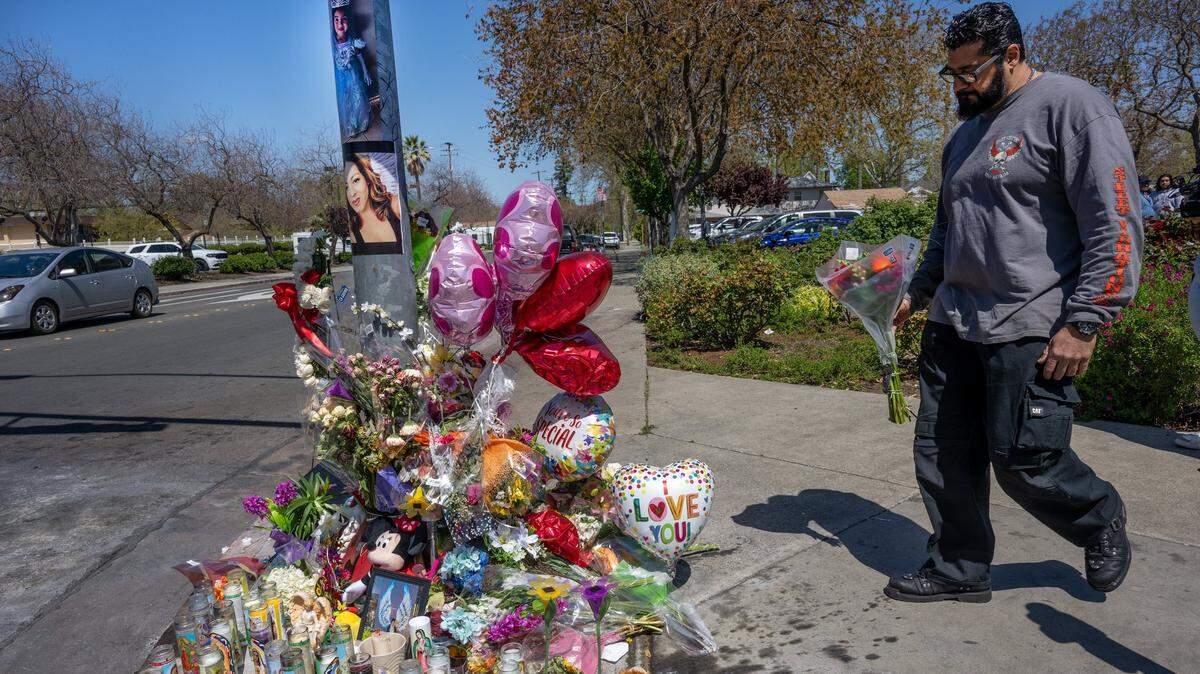 Faisal Rashid brings flowers to a memorial for crash victims Tina Vital and Adalina Perez, 4, near the intersection of College and Court streets in Woodland on Wednesday, April 12, 2023. He was a family friend of Vital, who was killed along with her granddaughter Adalina, when a 13-year-old boy who stole a car crashed into several vehicles. “Tina was a good family friend,” said Rashid. Both crash victims are pictured on the telephone pole.