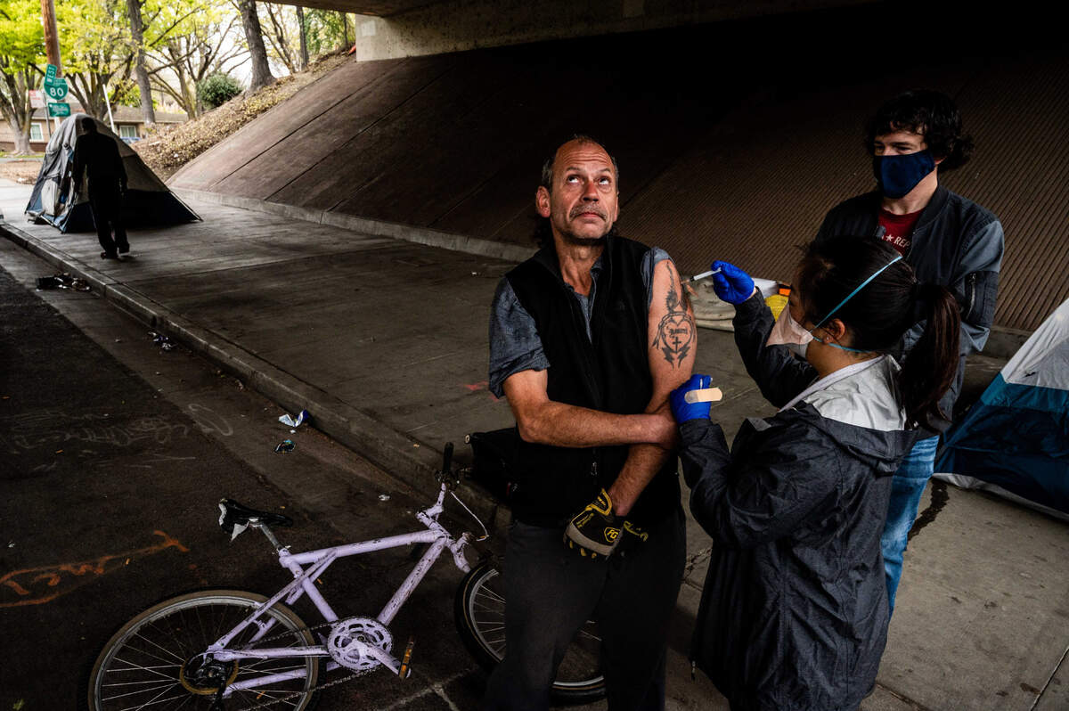 11. Charles Timberger, 51, who is experiencing homelessness, gets the Johnson & Johnson COVID-19 vaccine under the W-X freeway in Sacramento on Thursday, March 18, 2021.