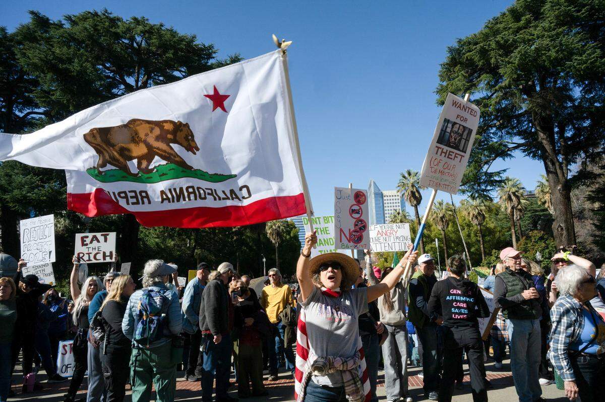 Hundreds of demonstrators hold signs and chant for causes at a protest against President Donald Trump and his adviser Elon Musk at the California Capitol on Wednesday.