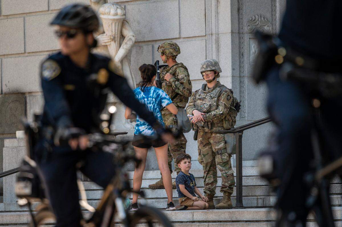 Elijah Ducey, 3, looks up while law enforcement officers and California National Guard patrol the California Stanley Mosk Library and Courts Building in Sacramento on Tuesday, June 2, 2020.