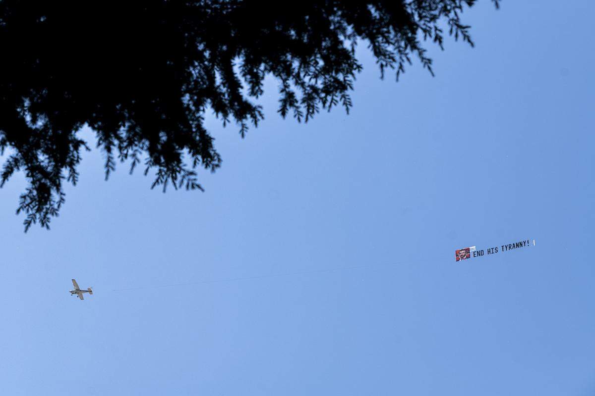 A plane flies over the state Capitol on Friday, May 1, dragging a banner with Gov. Gavin Newsom’s photo and the words “End his tyranny!” during a protest against the stay-at-home order to slow the spread of the coronavirus.