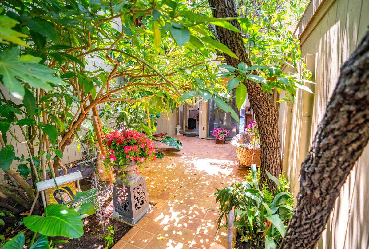 The two-level residence is entered through a large tropical courtyard filled with an assortment of trees and flowers, Thursday, May 25, 2023.