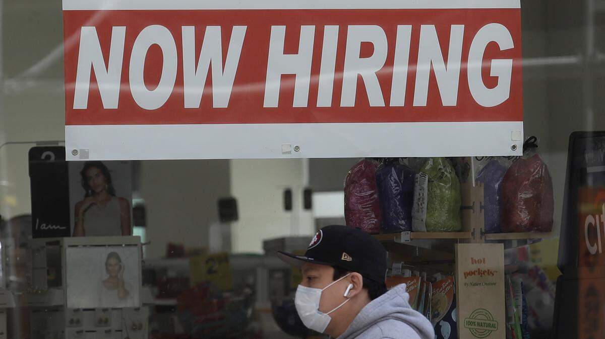 A man wears a mask during the coronavirus outbreak while walking under a Now Hiring sign at a CVS Pharmacy in San Francisco, Thursday, May 7, 2020. (AP Photo/Jeff Chiu)