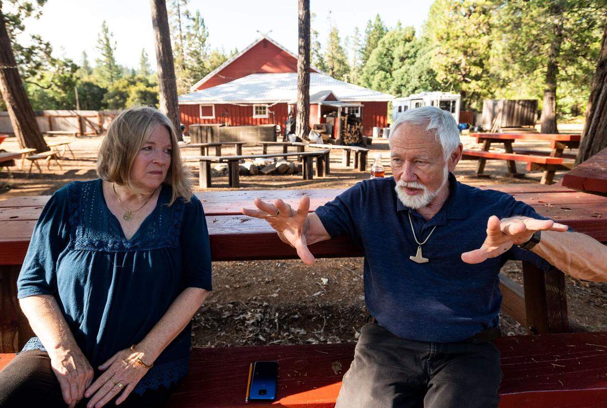 Stephen McNallen, right, founder of the whites-only Asatru Folk Assembly, and his wife, Sheila McNallen, are interviewed behind the ASA’s “Odinshof” on July 27, 2021, in Brownsville, Yuba County.