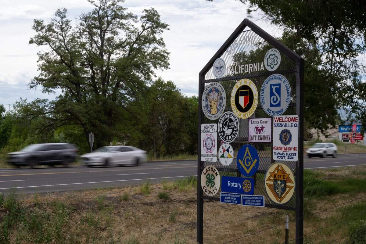 Cars travel past a sign welcoming visitors to Susanville, a Northern California town of about 17,000 residents, in August. Suspicions about Bradley Earl Reger, who moved to the community in 1967, lingered for years according to locals.