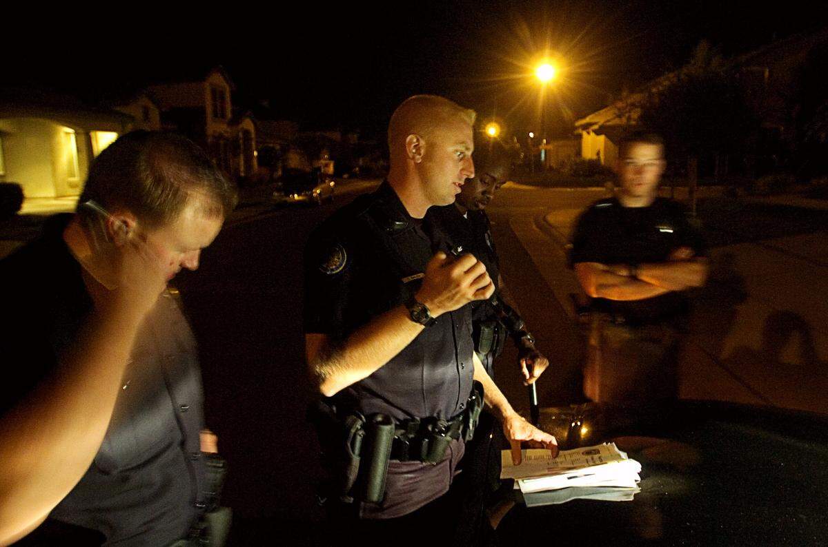 Zack Bales, center, confers with fellow officers during a Sacramento Police Department gang task force operation in Elk Grove in 2005. Bales, who was then working gang enforcement, is now set to lead the department as interim chief in 2026 after more than two decades with the agency.