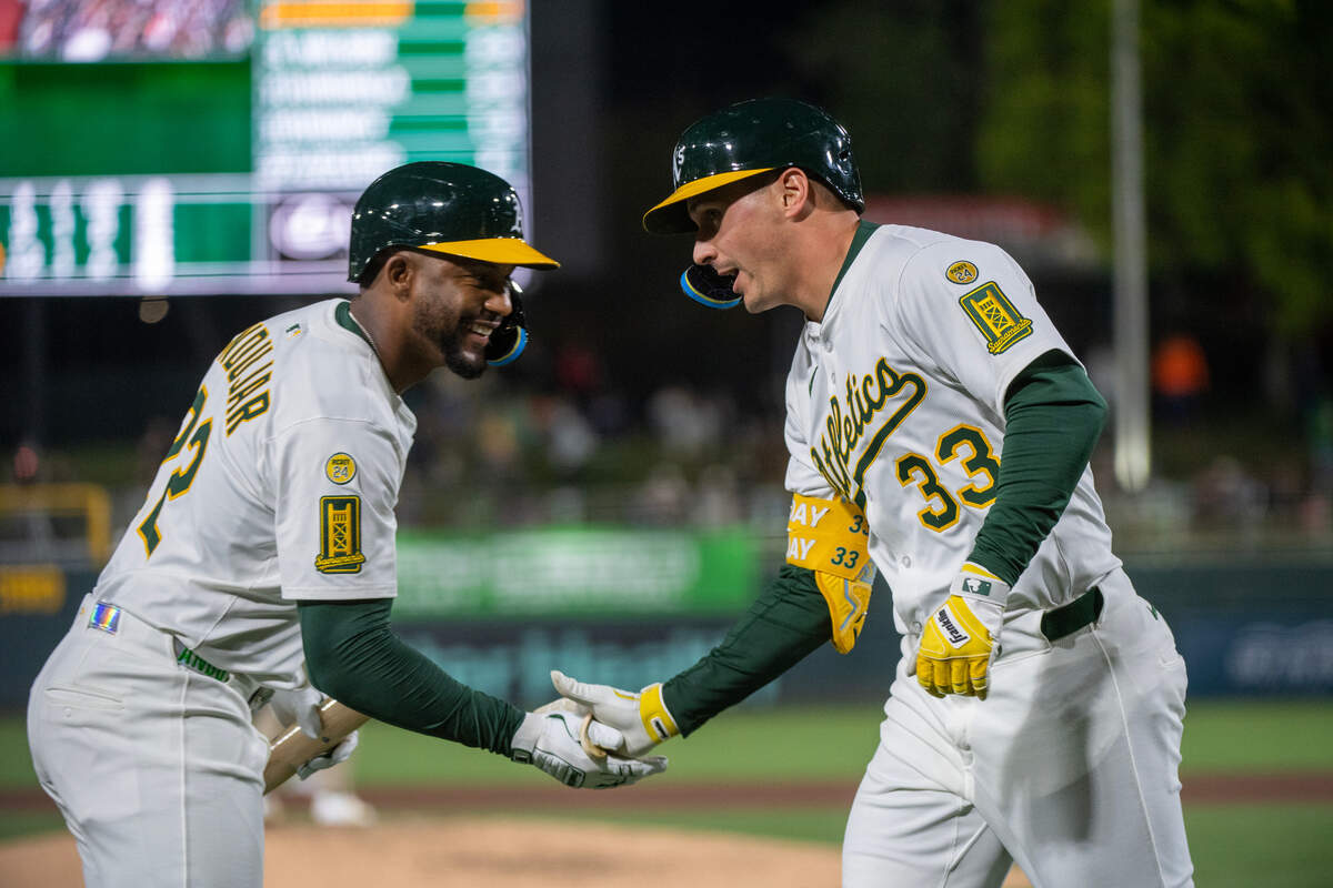 Athletics outfielder JJ Bleday (33) is greeted by teammate Miguel Andujar (22) after hitting a home run in the bottom of the seventh inning in a Major League Baseball game against the San Diego Padres on Tuesday at Sutter Health Park in West Sacramento.