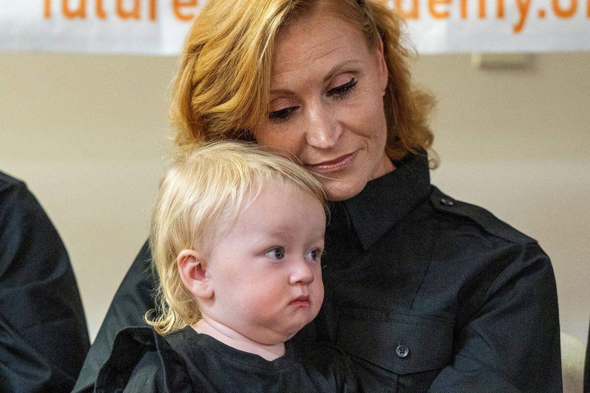 Firefighting program graduate Jamie Vaughn, 39, of Eureka, holds her granddaughter Johanna, 1, for the first time Tuesday during the Sacramento graduation ceremony for female inmates. Vaughn served time for causing great bodily injury or death while driving under the influence and possession of a controlled substance.