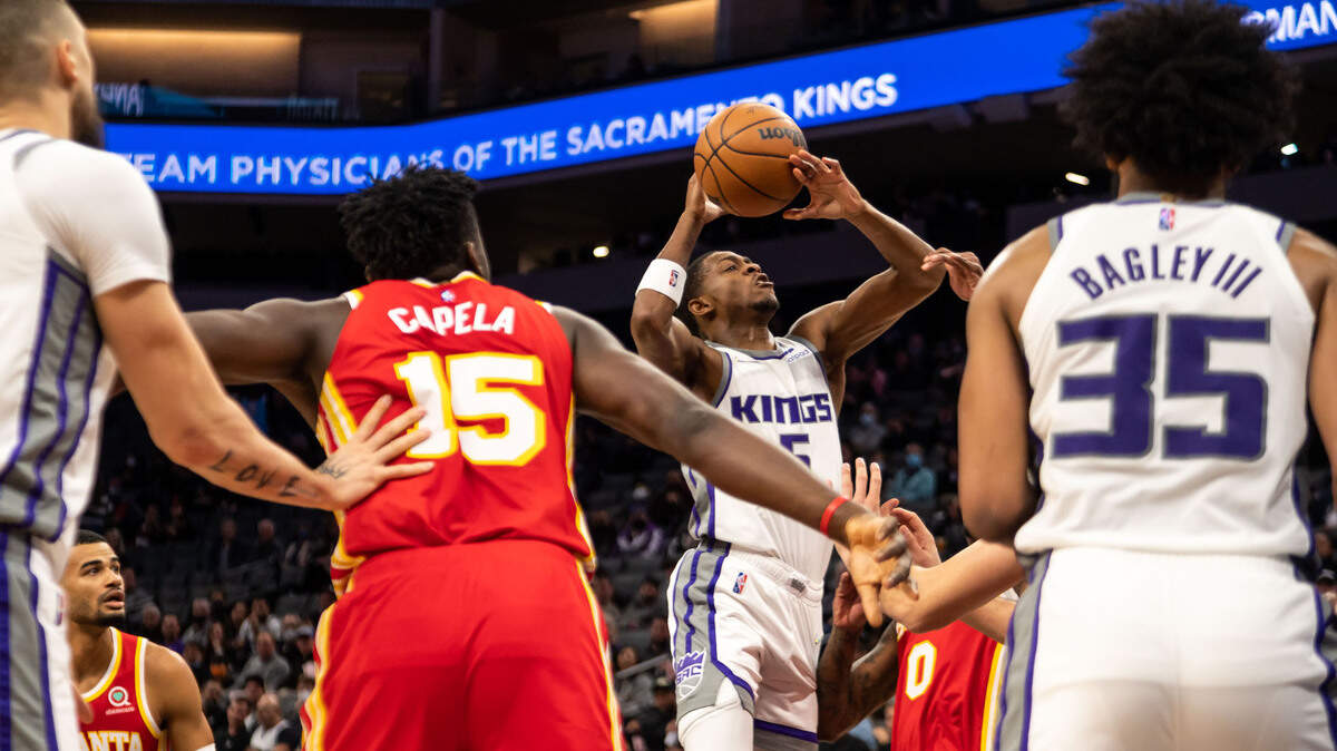 Sacramento Kings guard De’Aaron Fox (5) is fouled and blocked on the way up for a shot against the Atlanta Hawks during the first period of the NBA basketball game Wednesday, Jan. 5, 2022, at Golden 1 Center in Sacramento.