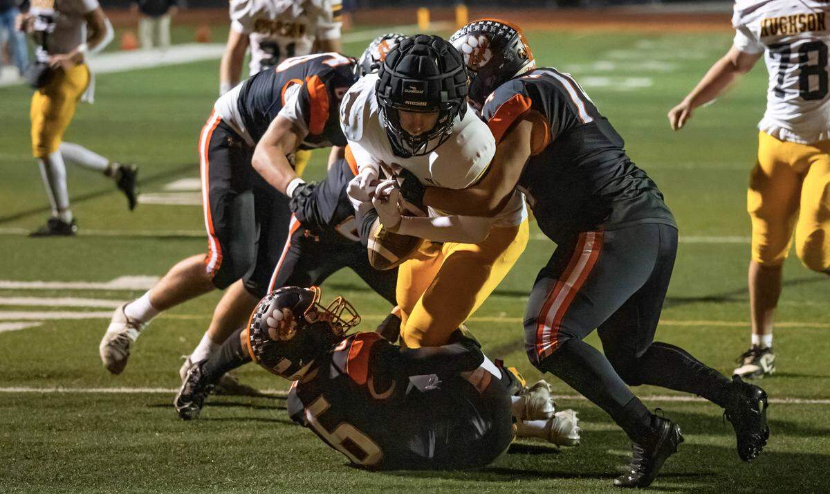 Roseville Tigers tackle Erick Aguilar (74) jars the ball loose from Hughson Huskies tight end Bryce McDaniel (13) near the goal line in the second half of a CIF Sac-Joaquin Section Division IV semifinal in Roseville on Friday, Nov. 21, 2025. The Tigers recovered the fumble.