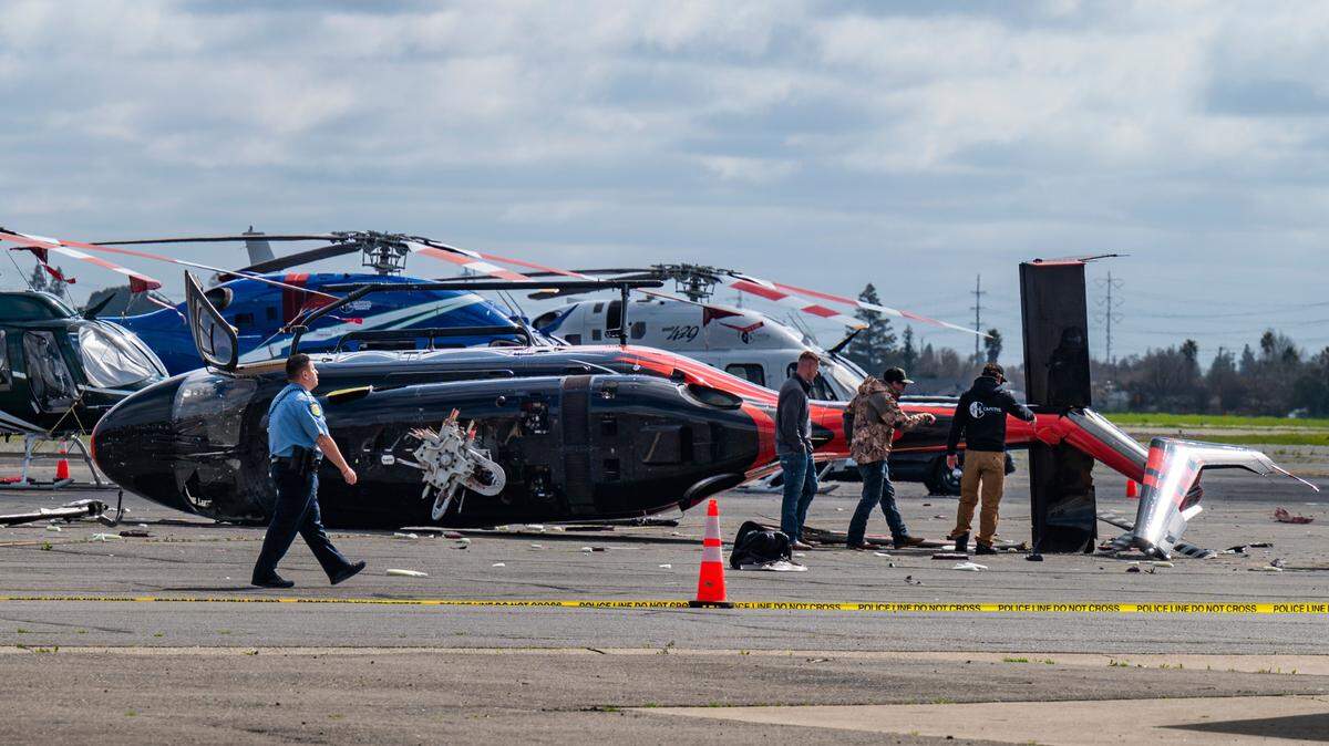 Officials inspect a crashed helicopter at Sacramento Executive Airport on Wednesday.