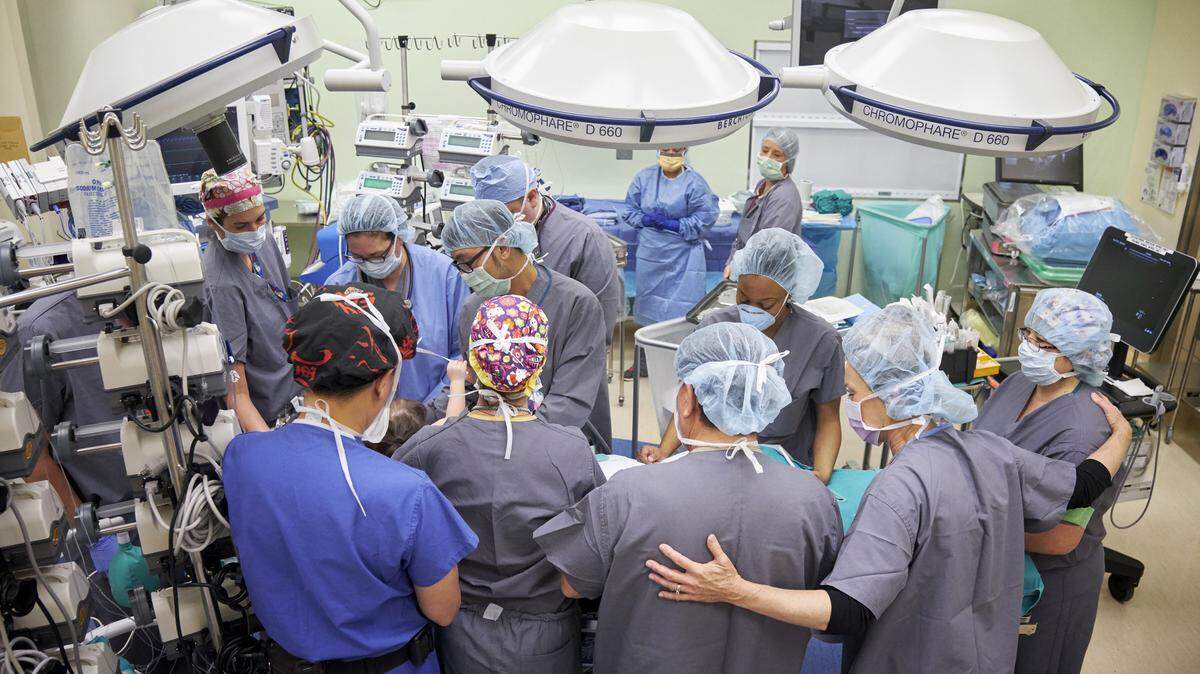 The operating room team gathers around the surgical table as they are led in prayer before performing separation surgery on conjoined Sacramento-area twins Eva and Erika Sandoval in December 2016 at Lucile Packard Children’s Hospital Stanford.