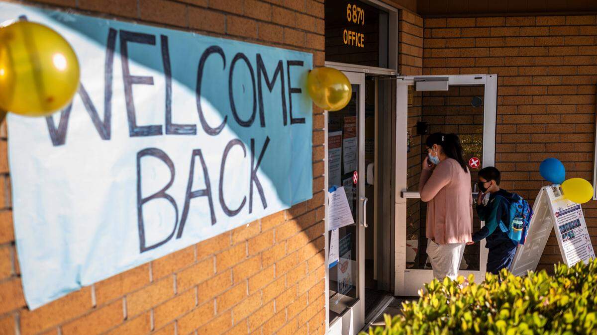 Students walk into school before the first bell at Caroline Wenzel Elementary in Sacramento on Thursday, April 8, 2021. Sacramento City Unified School District grades EK-3 returned to in-person learning on Thursday.
