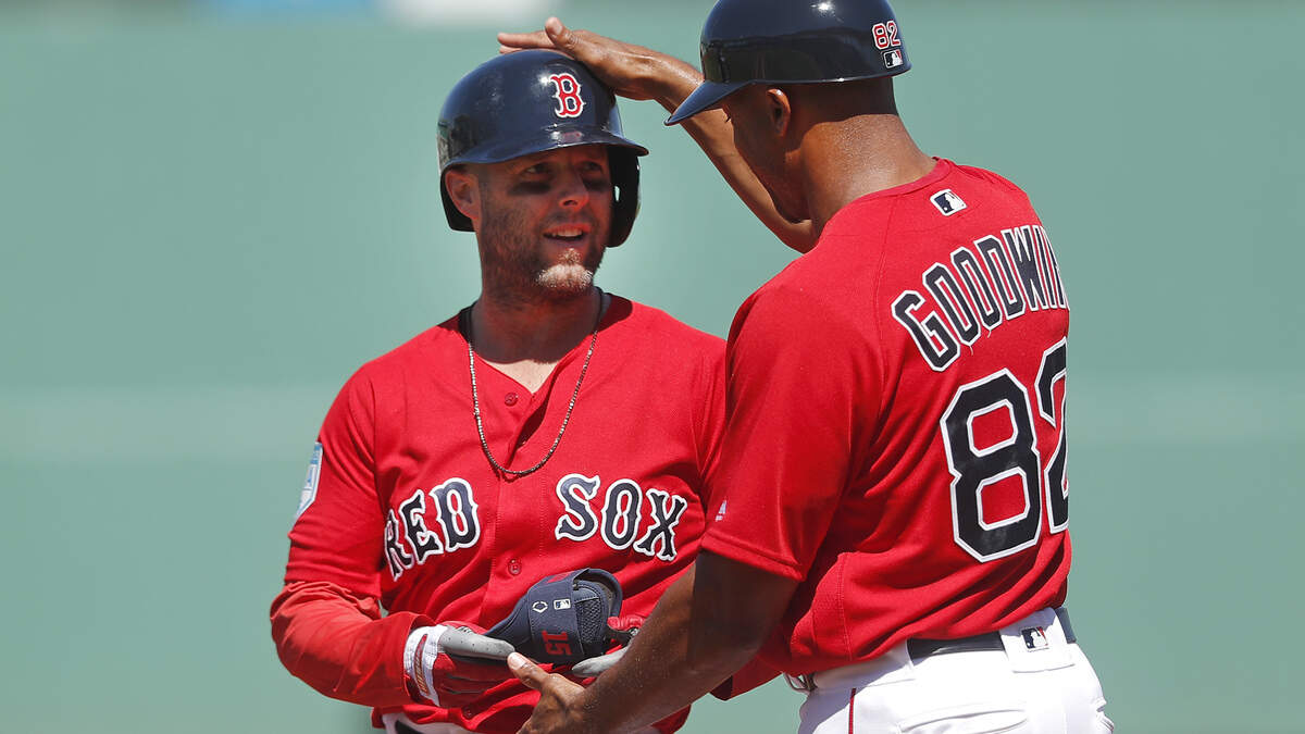 Boston Red Sox second baseman Dustin Pedroia is congratulated by Boston Red Sox first base coach Tom Goodwin after hitting a single in the first inning of a spring training baseball game against the Minnesota Twins Thursday, March 7, 2019, in Fort Myers, Fla. (AP Photo/John Bazemore)