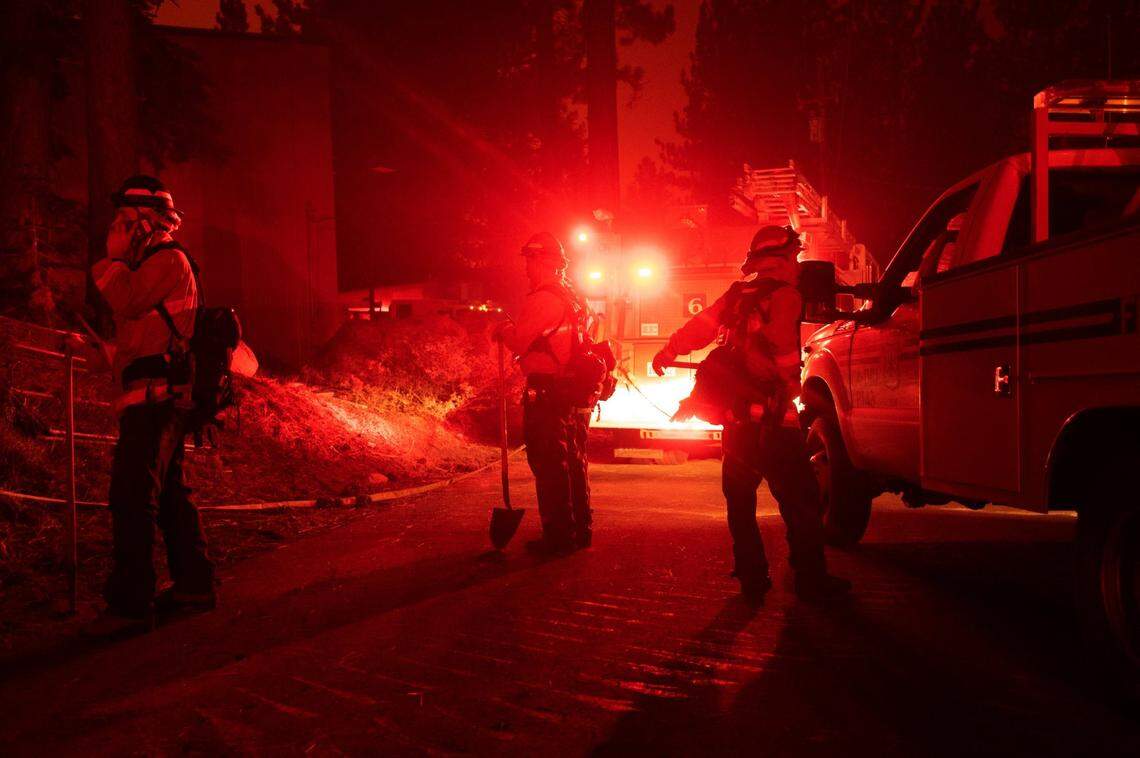 U.S. Forest Service Lake Tahoe Basin unit members protect buildings as they watch the Caldor Fire advance near Meyers on Monday night, Aug. 30, 2021.