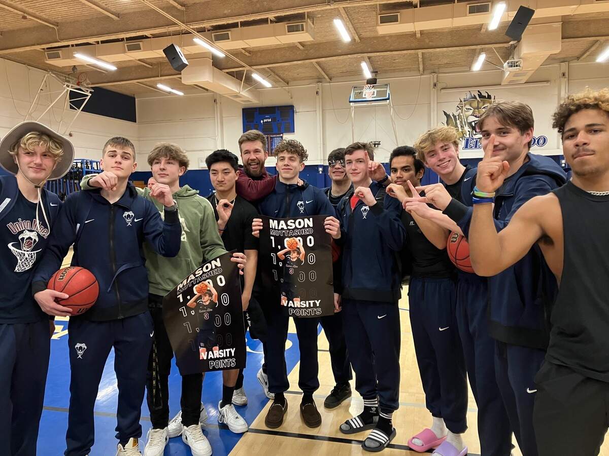 Mason Mottashed is joined by Union Mine High School basketball teammates after eclipsing the 1,000-point career mark.