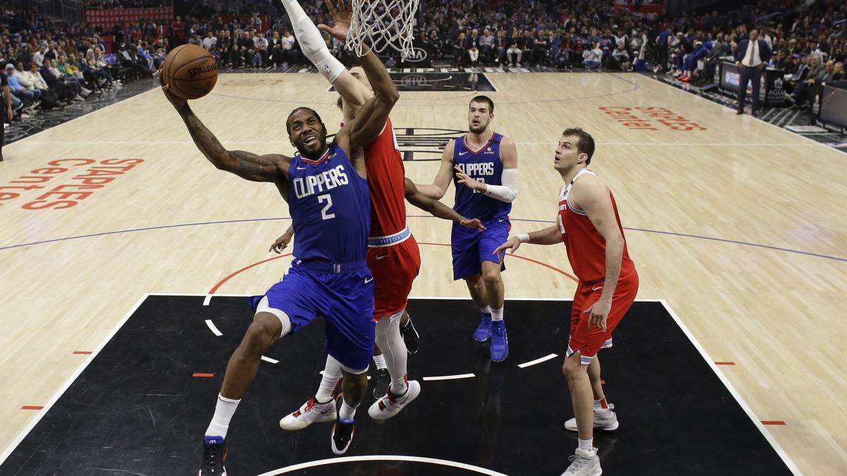 Los Angeles Clippers’ Kawhi Leonard drives to the basket defended by Sacramento’s Alex Len on Saturday.