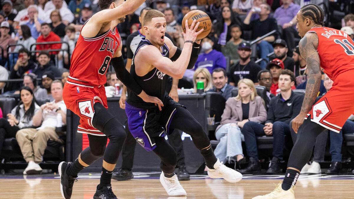 Sacramento Kings guard Donte DiVincenzo (0) drives to the basket between Chicago Bulls guard Zach LaVine (8) and forward DeMar DeRozan (11) during the fourth quarter on Monday, March 14, 2022 during an NBA basketball game at the Golden 1 Center in Sacramento. DiVincenzo had 15 points and seven rebounds. The Kings defeated the Bulls 112-103.