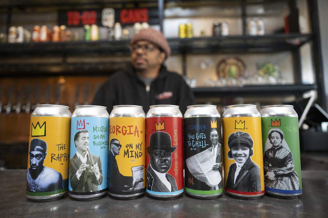 Rodg Little, co-owner and brewer at Oak Park Brewing, displays various collaborations the brewery has done, including with the estate of Tupac Shakur, at the brewery in Sacramento on Feb. 19. According to Little, the beers were the first time Black Americans appeared on beer cans.