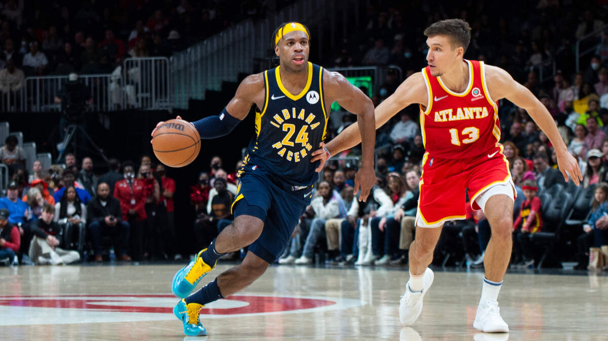 Indiana Pacers guard Buddy Hield (24) dribbles past Atlanta Hawks guard Bogdan Bogdanovic (13) during the second half of an NBA basketball game Sunday, March 13, 2022, in Atlanta. (AP Photo/Hakim Wright Sr.)