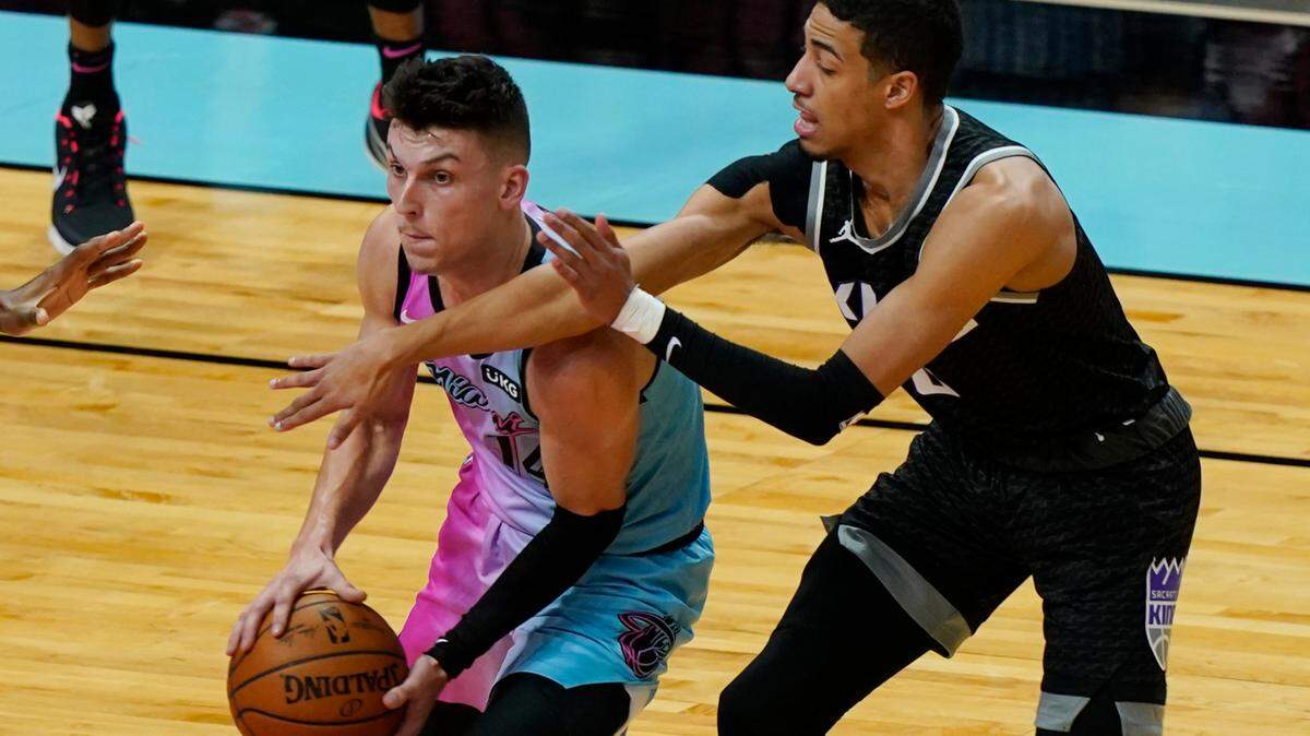 Miami Heat guard Tyler Herro (14) looks to pass the ball under pressure from Sacramento Kings guard Tyrese Haliburton (0) during the first half of an NBA basketball game, Saturday, Jan. 30, 2021, in Miami. (AP Photo/Marta Lavandier)