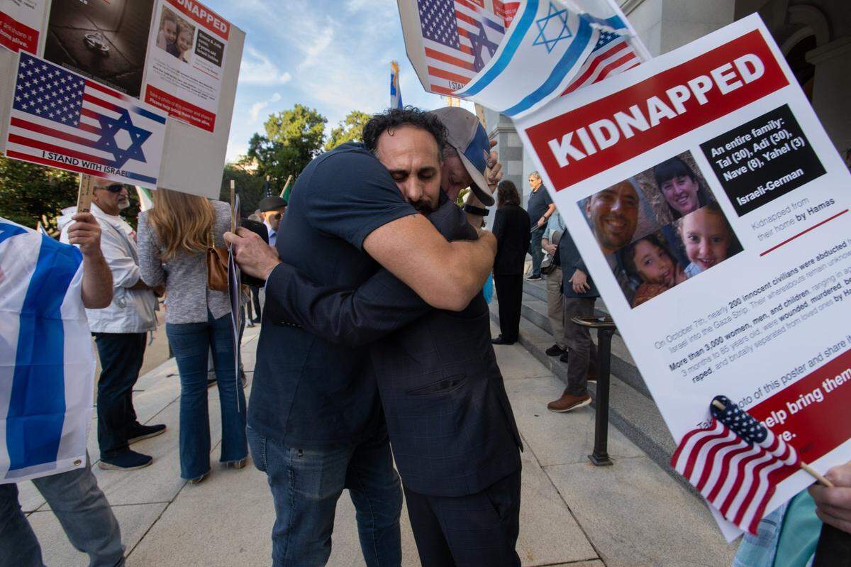 Ryan Pessah, right, hugs Mina Biterman during a vigil helds by the Jewish Federation of the Sacramento Region at the state Capitol on Monday. Pessah’s family members have been kidnapped and held hostage from the Nir Oz Kibbutz. Speakers at the vigil called for the release of the more than 200 hostages held by Hamas in Gaza.