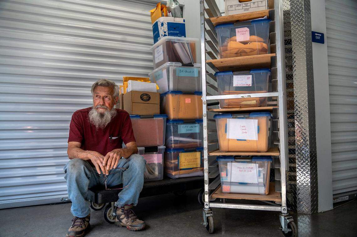 Dan Altstatt sits next to bins of legal paperwork at his storage unit in Sacramento on March 18. “There is no such thing as fair,” said Altstatt, who says the city code enforcement citations and legal battle over the past seven years have had a negative impact on his health.