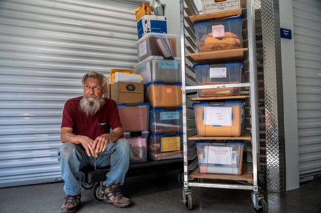 Dan Altstatt, 83, sits next to bins of legal paperwork at his storage unit in Sacramento on Friday, March 18, 2022. “There is no such thing as fair,” said Altstatt, who says the city code enforcement citations and legal battle over the past seven years have had a negative impact on his health.