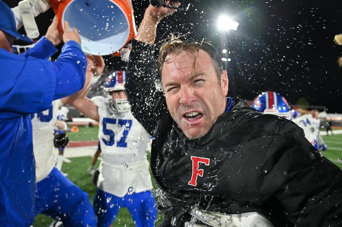 Folsom Bulldogs coach Paul Doherty gets doused with water after winning the CIF division 1-A state football championship against the St. Bonaventure Seraphs on Saturday, Dec. 9, 2023, at Saddleback College in Mission Viejo.