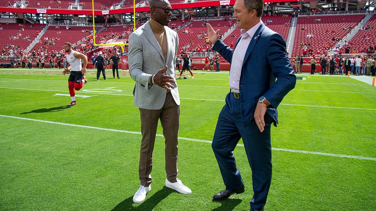 Former San Francisco 49ers wide receiver Terrell Owens greets general manager John Lynch during a game at Levi’s Stadium on Sunday Sept. 22, 2019, in Santa Clara.