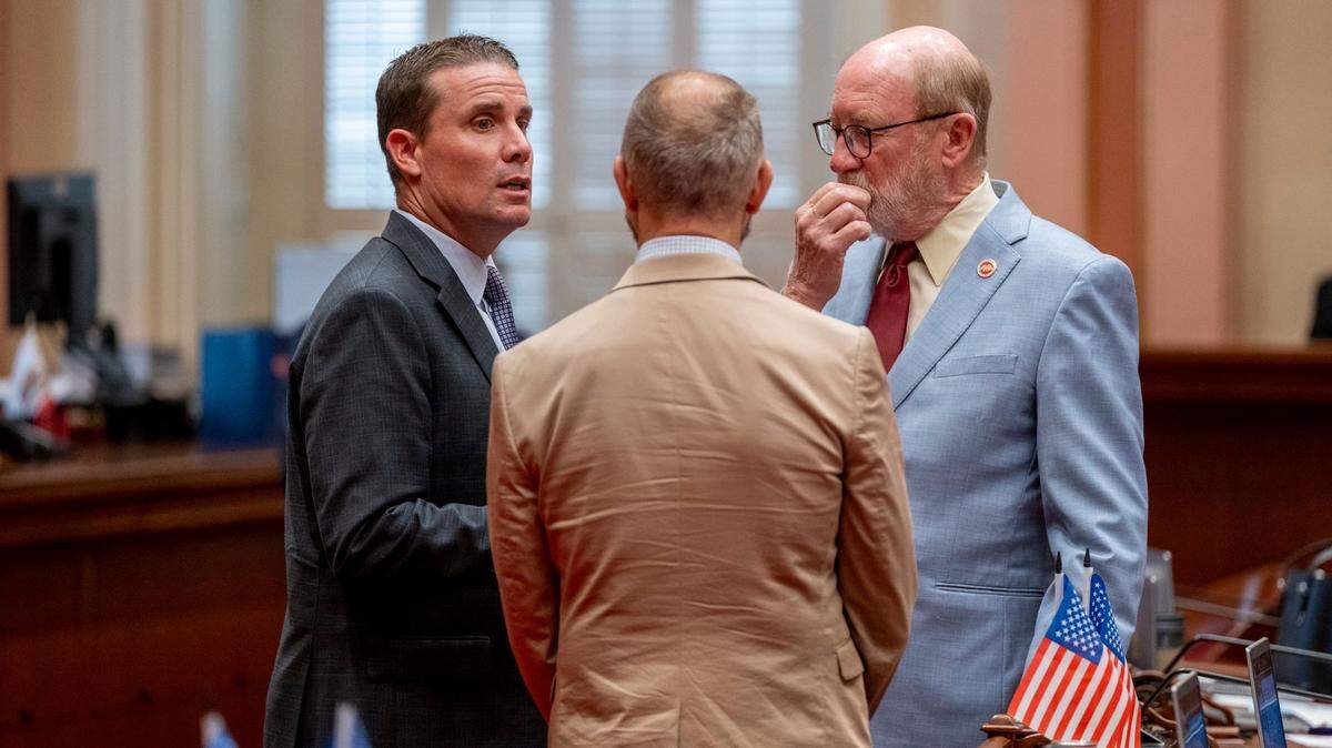 Senate President pro Tem Mike McGuire, D-Santa Rosa, left, and state Sens. Christopher Cabaldon, D-West Sacramento, center, and John Laird, D-Santa Cruz huddle during debate on the California budget proposal at the Capitol in Sacramento on Friday.