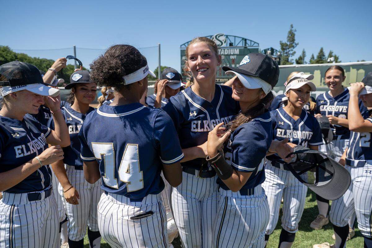 The Elk Grove Thundering Herd's Cole Dennis is embraced by teammates following their 3-2 victory over the Del Oro Golden Eagles on Saturday in the CIF Sac-Joaquin Section Division II softball championship at Sacramento State.