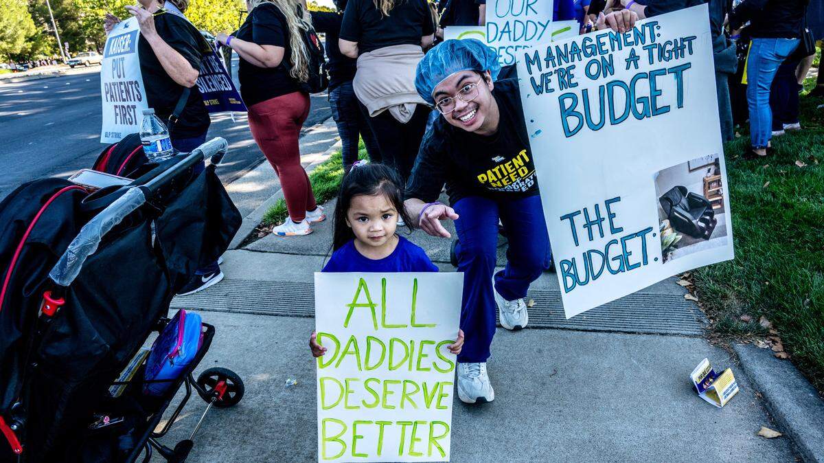 RJ Monteagudo, right, a sterile processing technician at Kaiser Permanente Roseville Medical Center, was joined by daughter Ria, 4, on the strike line with other health care workers on Wednesday.