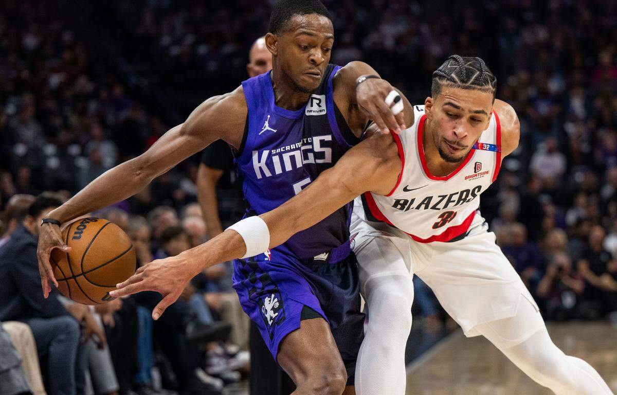 With two fingers on his left hand taped together, Sacramento Kings guard De’Aaron Fox (5) dribble past Portland Trail Blazers forward Toumani Camara (33) at Golden 1 Center on Oct. 28.