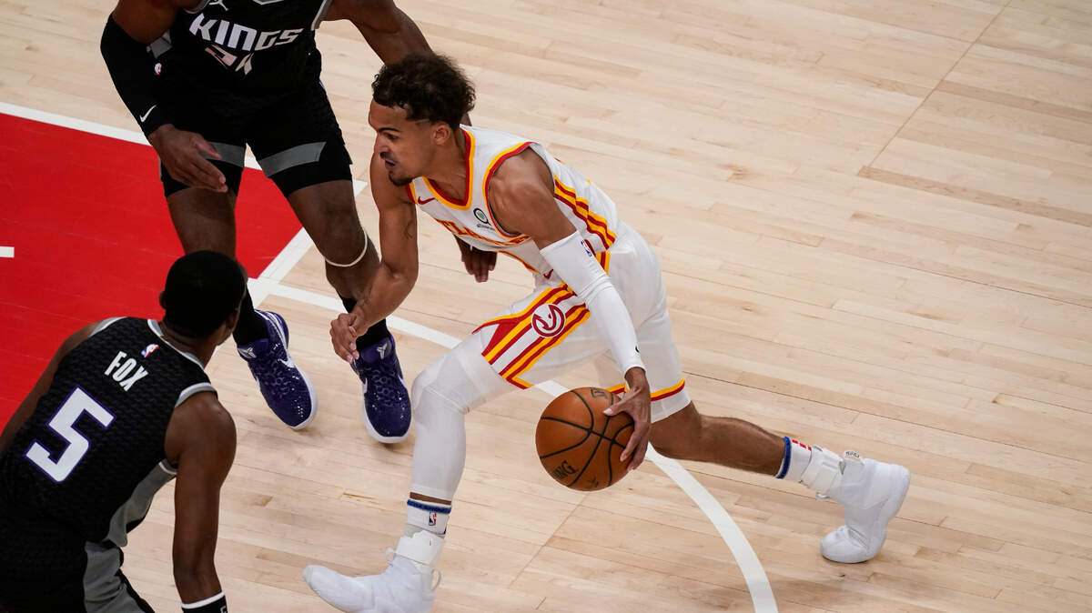 Atlanta Hawks’ Trae Young (11) dribbles the ball against Sacramento Kings guard De’Aaron Fox (5) during the first half of an NBA basketball game on Saturday, March 13, 2021, in Atlanta. (AP Photo/Brynn Anderson)