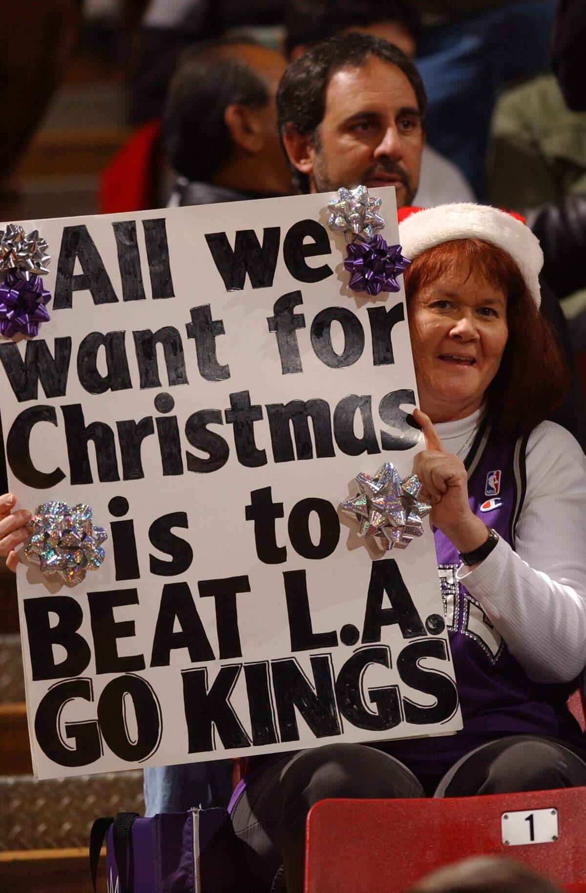 Sacramento Kings fan Barbara Rust, of Folsom, shows the Kings players her Christmas wish in 2002 at Arco Arena.
