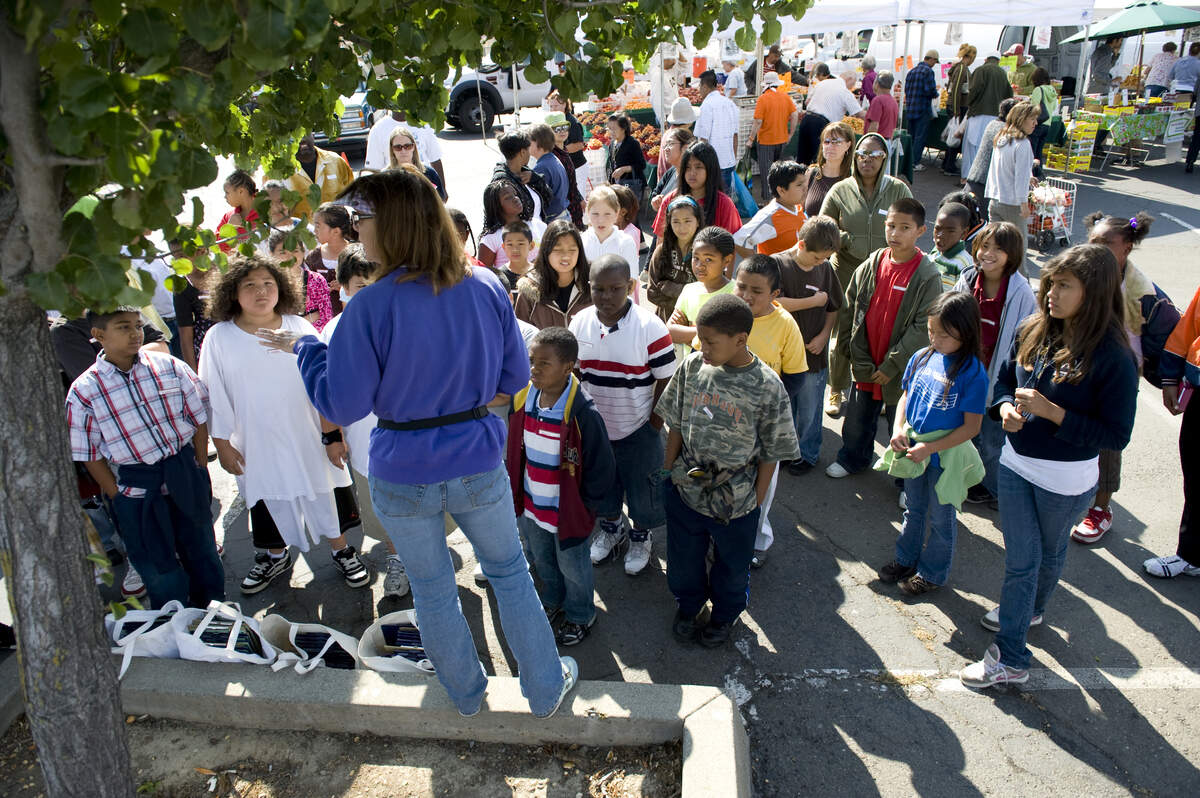 Renae Best talks to students before they go on a search for different fruits and vegetables at the Florin Farmers Market in 2008. The tours are being relaunched under the management of Alchemist Community Development Corp. thanks to a grant from the U.S. Conference of Mayors.