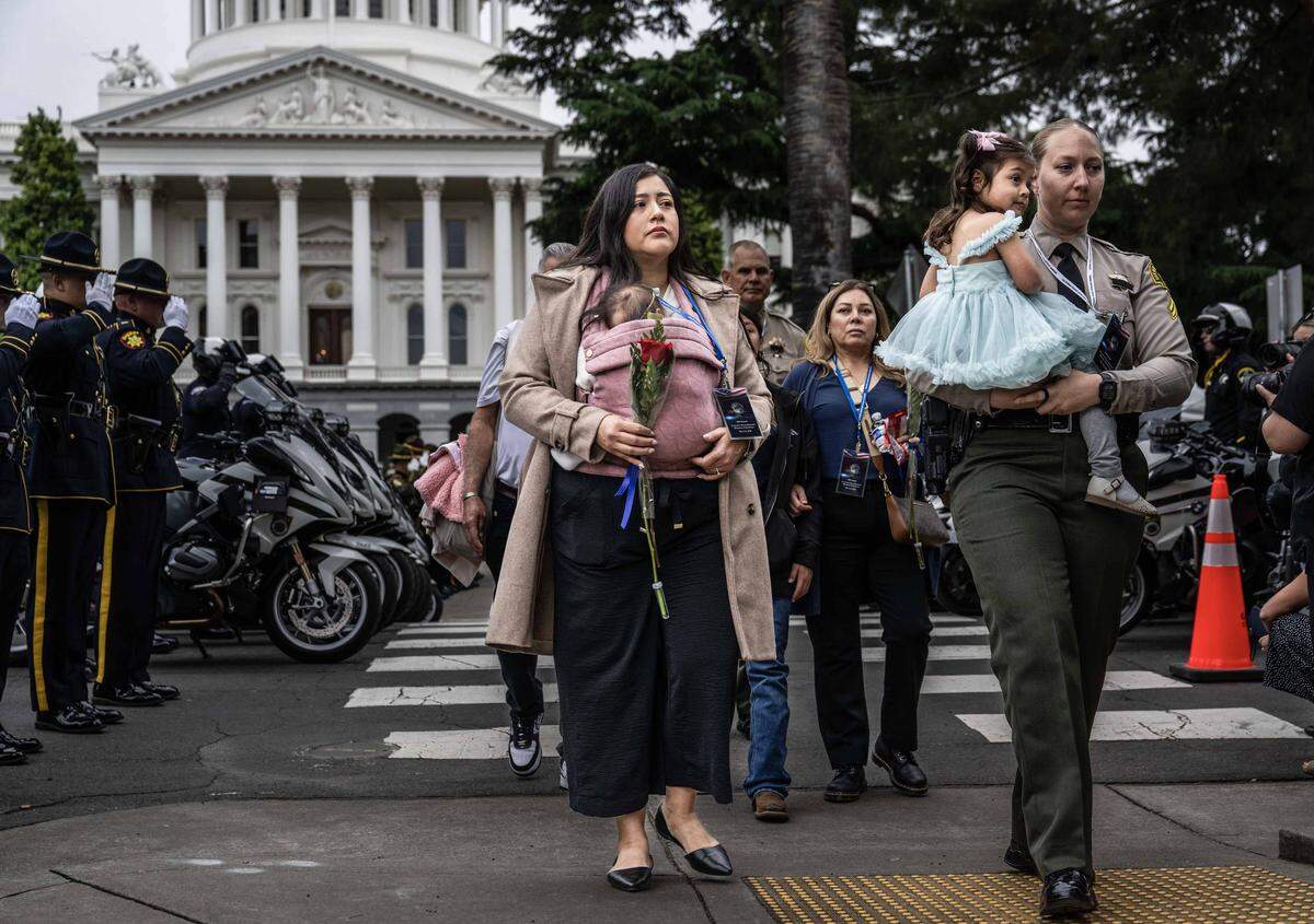 Roxana Nunez carries her daughter, who was born after her husband San Bernardino deputy Andrew Nunez died in the line of duty last year, during the 48th annual California Peace Officers’ Memorial enrollment ceremony in Sacramento on Monday.