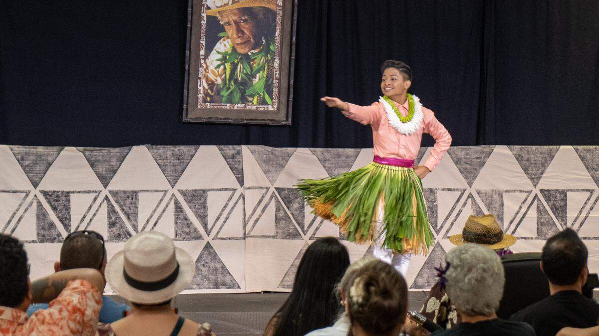 Thirteen-year-old Kekoa Arucan performs a playful opening hula of the George Na’ope Hula Festival, set to a song originally composed for the opening of the Royal Hawaiian Hotel in Honolulu, on Friday. A portrait of George Na’ope, the late hula master that the festival is named after, hangs on the stage backdrop.