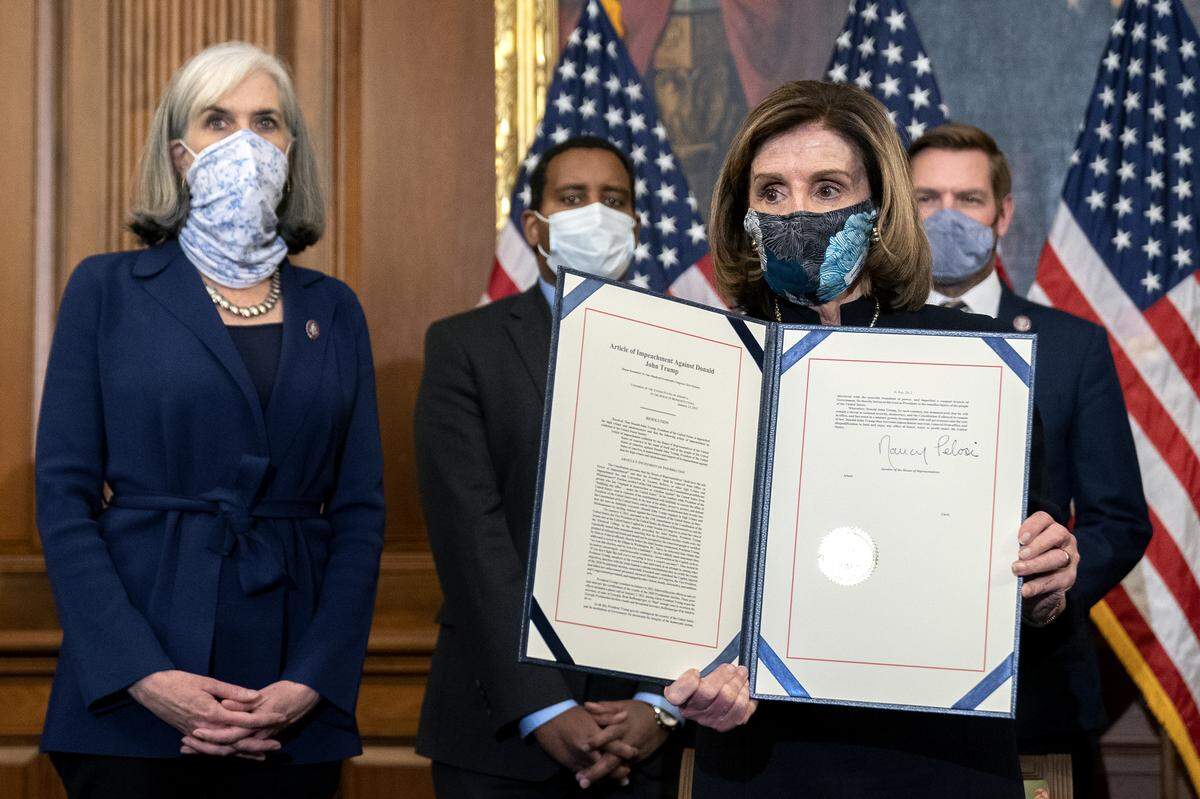 Speaker of the House Nancy Pelosi , D-Calif., displays a signed an article of impeachment against President Donald Trump at the U.S. Capitol on Jan. 13, 2021. The House of Representatives voted to impeach Trump for incitement of insurrection.