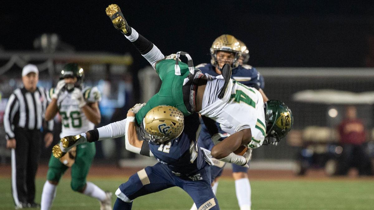 Monterey Trail’s Brevin Amiga (14) makes a catch for the first down before being tackled by Central Catholic’s Nolan Croasdale (12) on Saturday, Nov. 27, 2021, during the CIF Sac-Joaquin Division II championship game at Hughes Stadium in Sacramento.