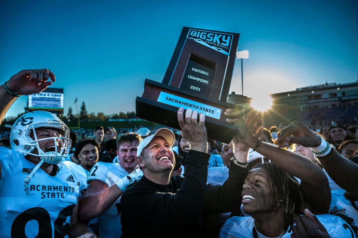 Sacramento State Hornets coach Troy Taylor lifts the Big Sky Conference trophy on Saturday, Nov. 20, 2021, after his team beat UC Davis 27-7 during the Causeway Classic football game at UC Davis Health Stadium.