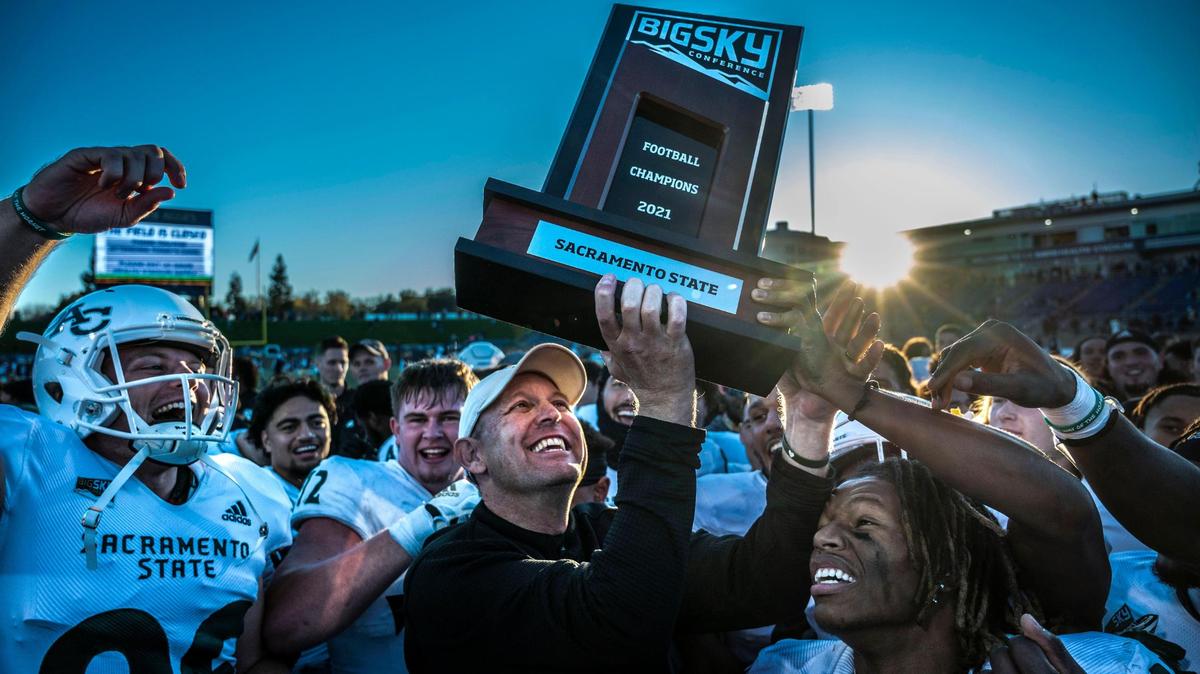 Sacramento State Hornets coach Troy Taylor lifts the Big Sky Conference trophy in 2021, after his team beat UC Davis 27-7 during the Causeway Classic football game at UC Davis Health Stadium.