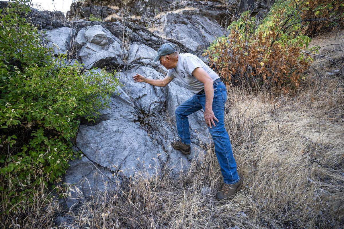 Jim Wood, a board member with the nonprofit Colfax Lime Kiln Preserve, demonstrates on last month how limestone was extracted using dynamite at a historic quarry in Placer County.