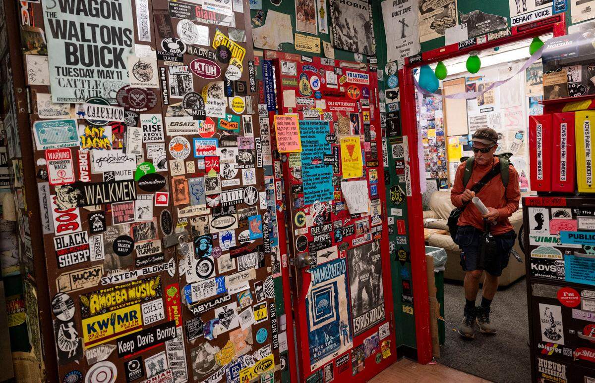 Guy Tortorici, a KDVS DJ known as “Muse” walks through the station Wednesday where posters and stickers collected over the past 60 years line the walls and ceilings. The student-run radio station at UC Davis will soon be relocating.