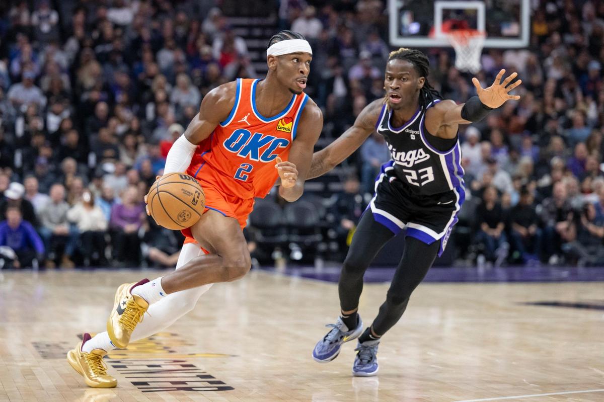 Oklahoma City Thunder guard Shai Gilgeous-Alexander (2) dribbles to the basket around Sacramento Kings guard Keon Ellis (23) in the first half of the NBA basketball game on Thursday, Dec. 14, 2023, at Golden 1 Center.