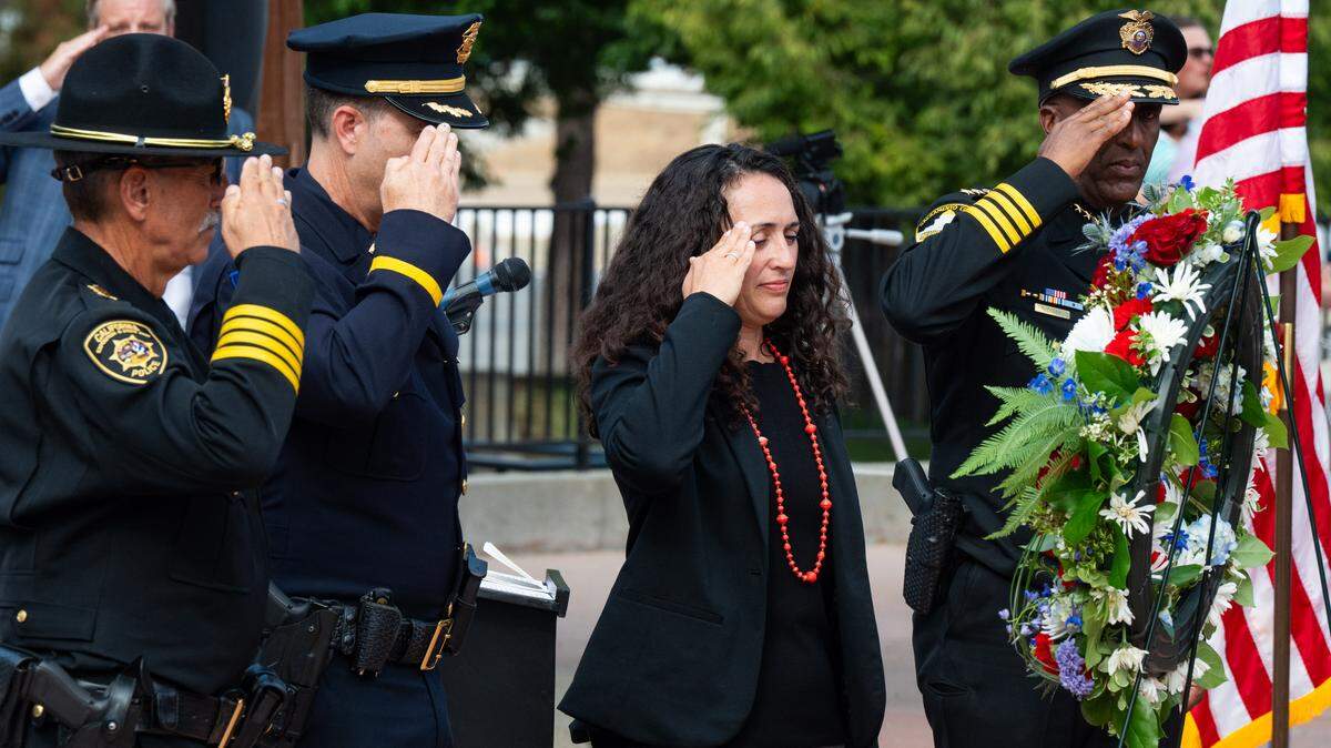 Jenny Leilani Callison, center, an Army veteran and former legislative consultant, joins local law enforcement members from left, Craig Walton, Doug Morse and Sheriff Jim Cooper in a salute after the wreath was laid in front of the girder from the twin towers during the 9/11 Remembrance Ceremony at Cal Expo in Sacramento on Thursday.