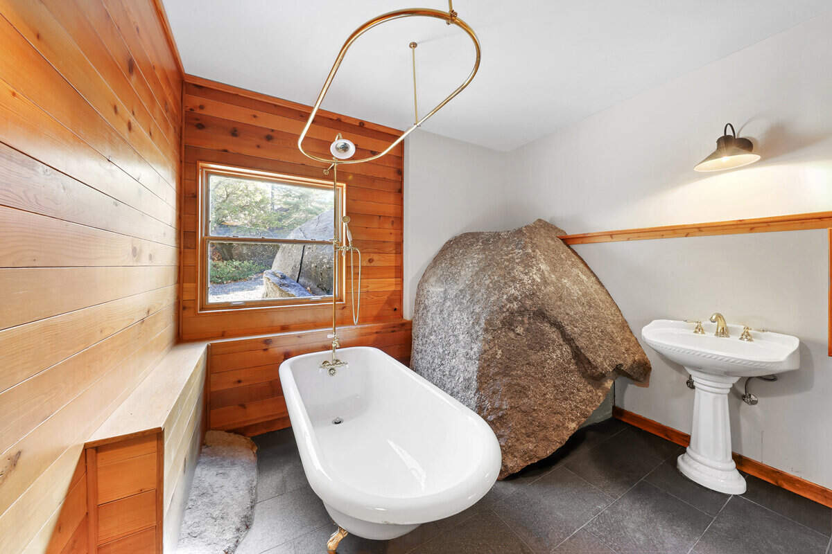 Granite Shores incorporates massive natural boulders into its architecture, with stone structures rising through bedrooms, bathrooms, and living spaces for a seamless indoor-outdoor connection.